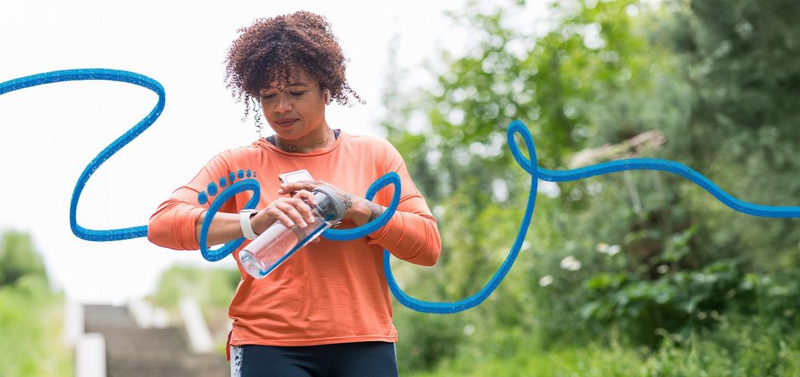 Person walking outside, looking down at their watch