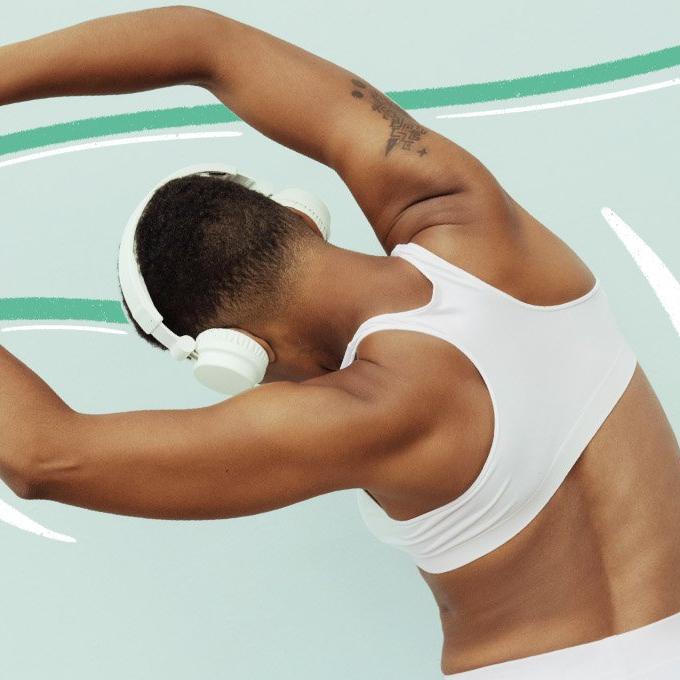 A person stretching wearing headphones on a blue background
