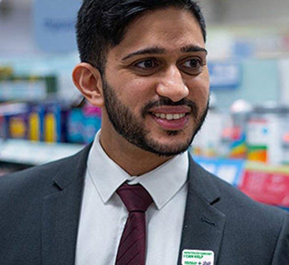 A man wearing a shirt and tie, smiling