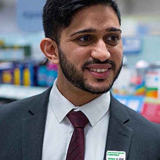 A man wearing a shirt and tie, smiling