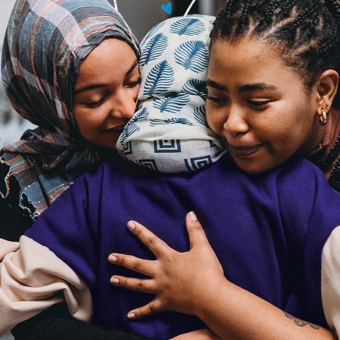 3 women stood with their arms around each others back