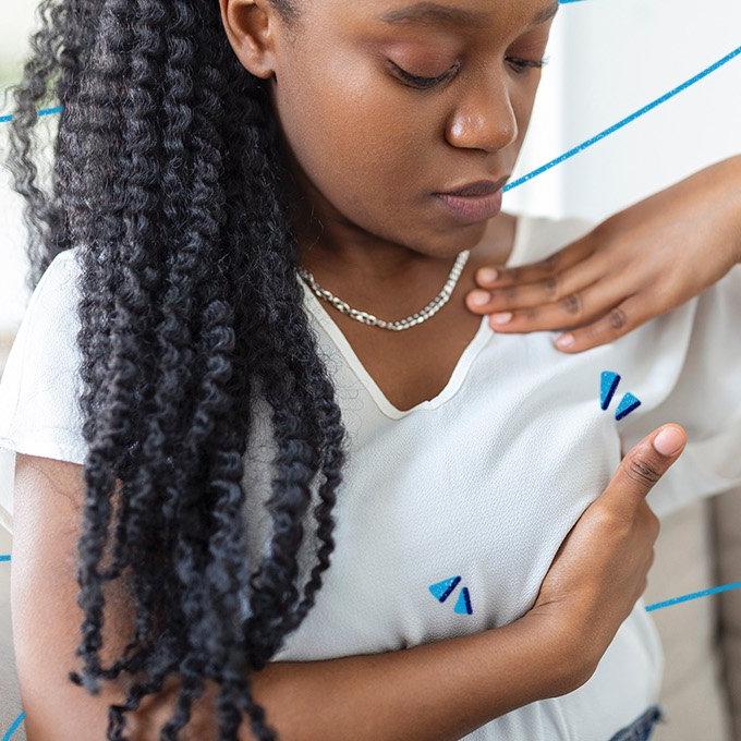 A woman doing a self-examination of their breasts