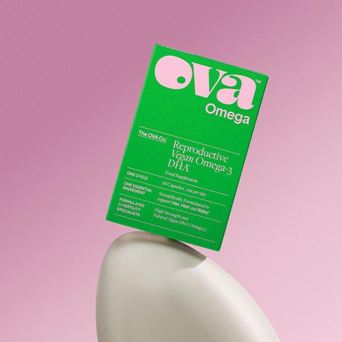 A green box of "ova Omega" reproductive vegan Omega-3 DHA supplement on a pink background