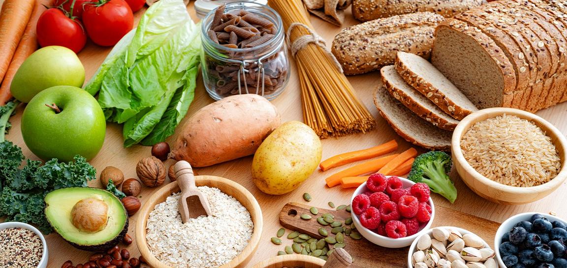 Assortment of fruits, vegetables, grains, and nuts on a wooden surface.
