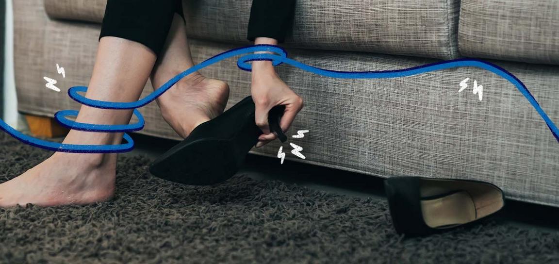 Person removing a black shoe with a swirling blue line around their ankle and hand