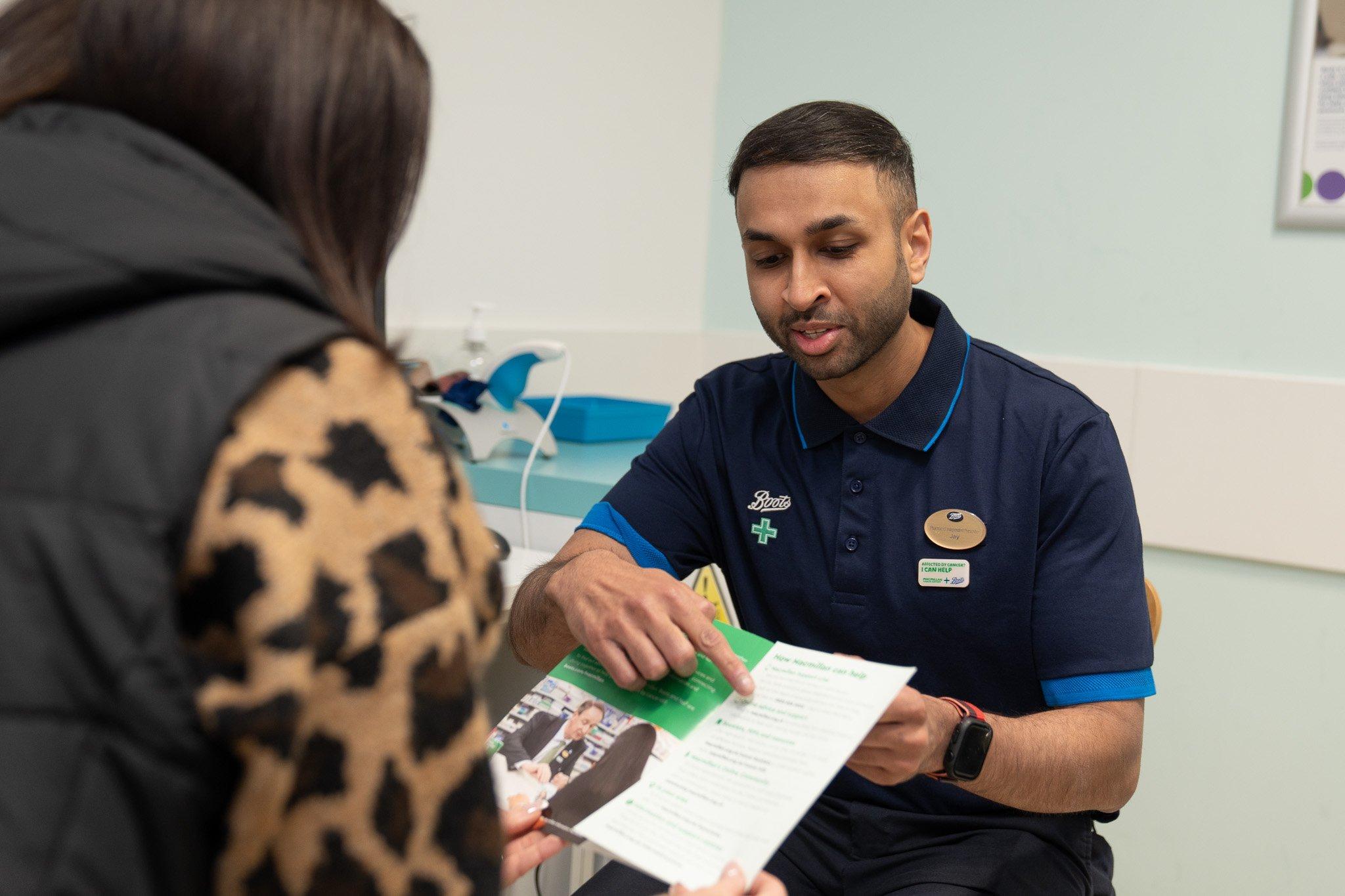 A pharmacist discussing an information booklet with a patient