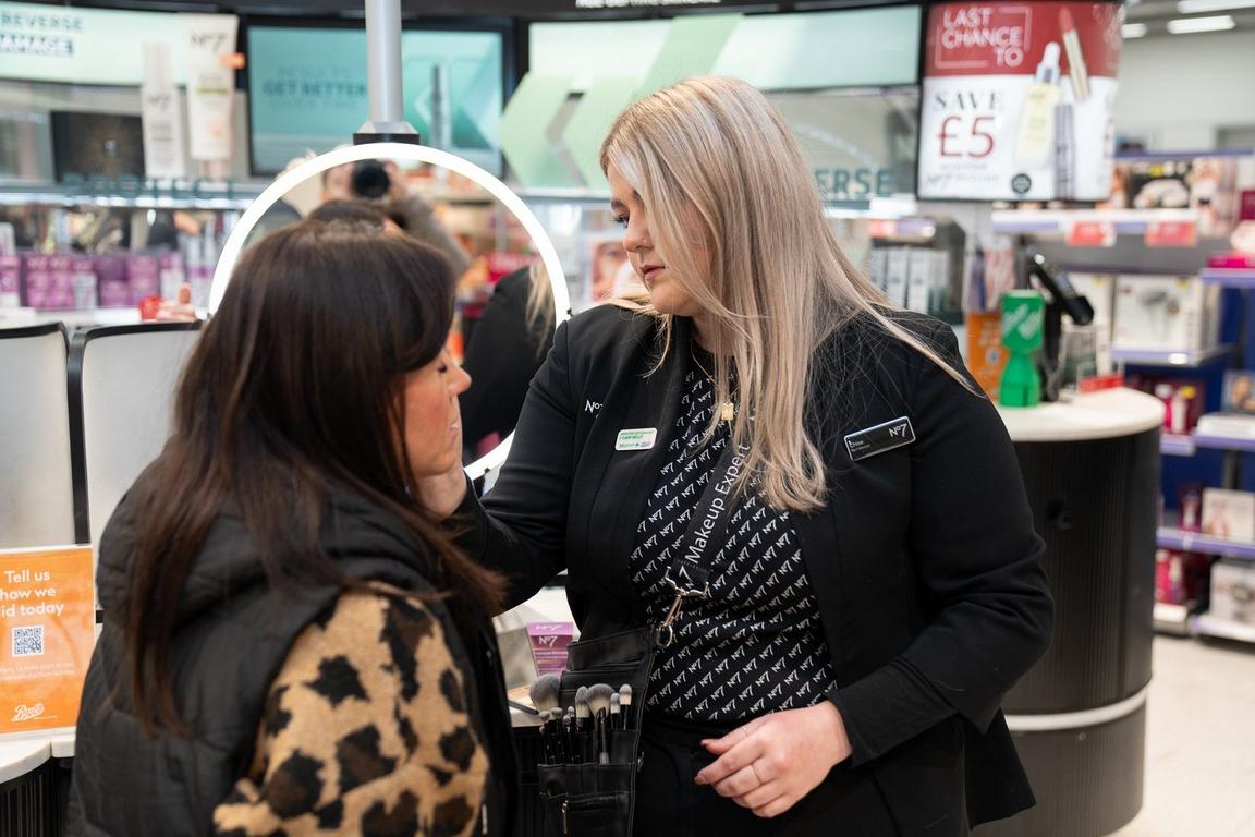 A Boots beauty consultant applying makeup to a customer in a store