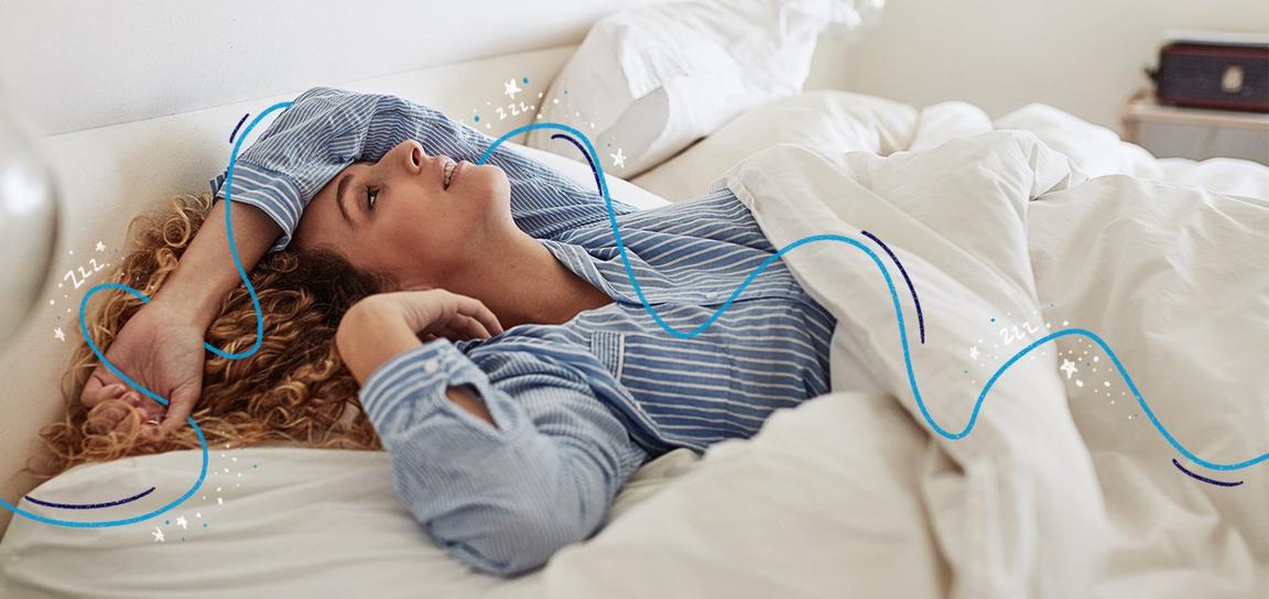 Someone wearing blue-striped pajamas lying in bed