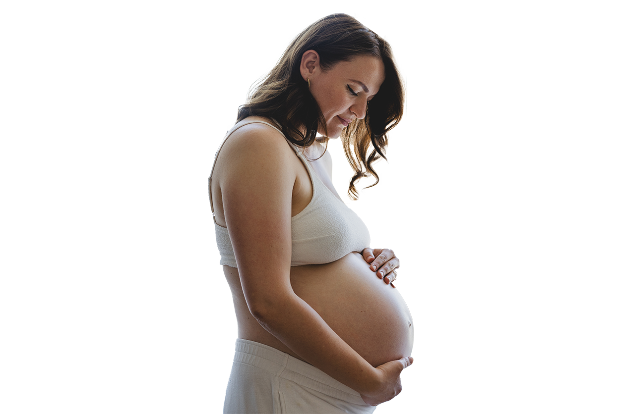 A pregnant woman looking down, holding her bump
