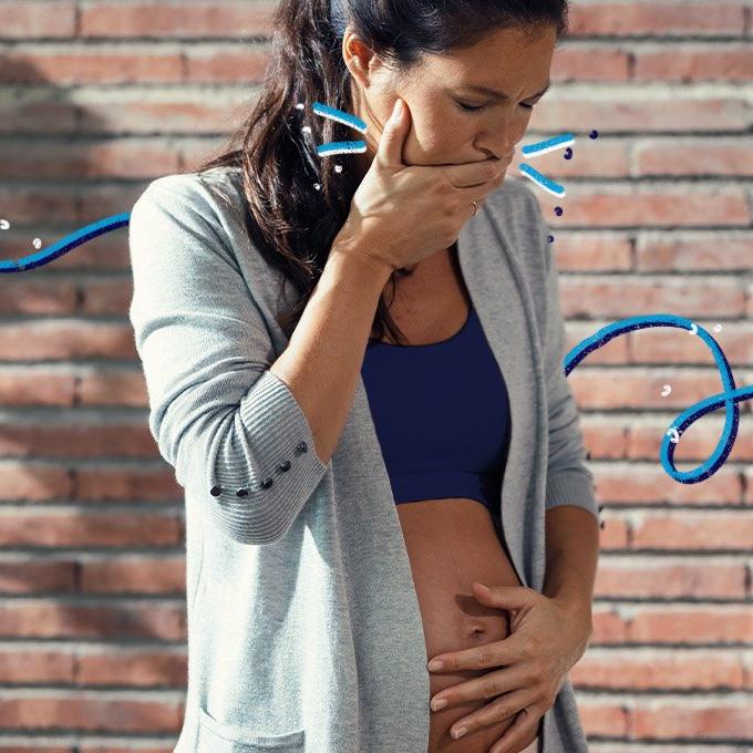 A pregnant woman holding with one hand on her stomach and one hand over her mouth