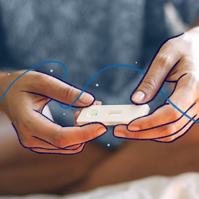 Close-up of hands holding a pregnancy test