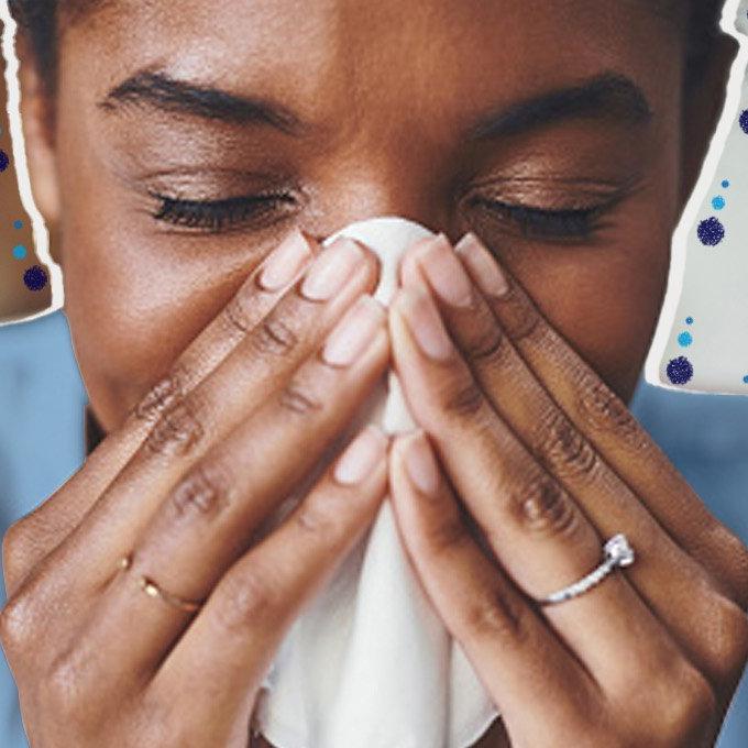 Someone blowing their nose into a tissue with closed eyes