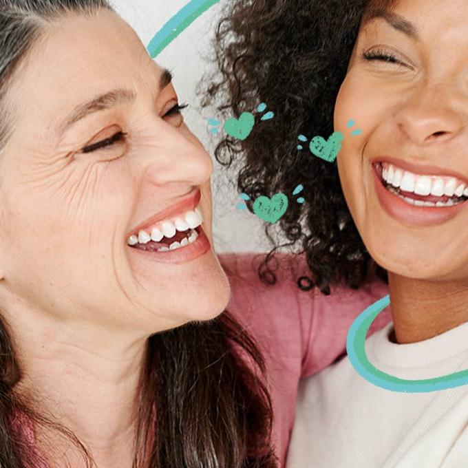 2 women hugging and smiling at each other