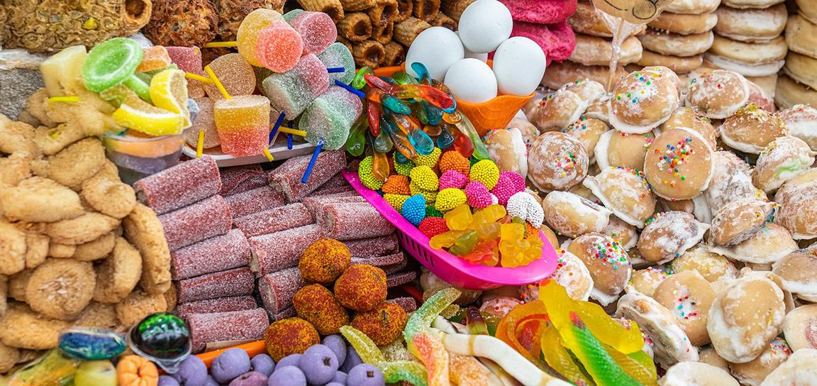 A colorful assortment of candies and pastries, featuring gummies, marshmallows, and sprinkled pastries.