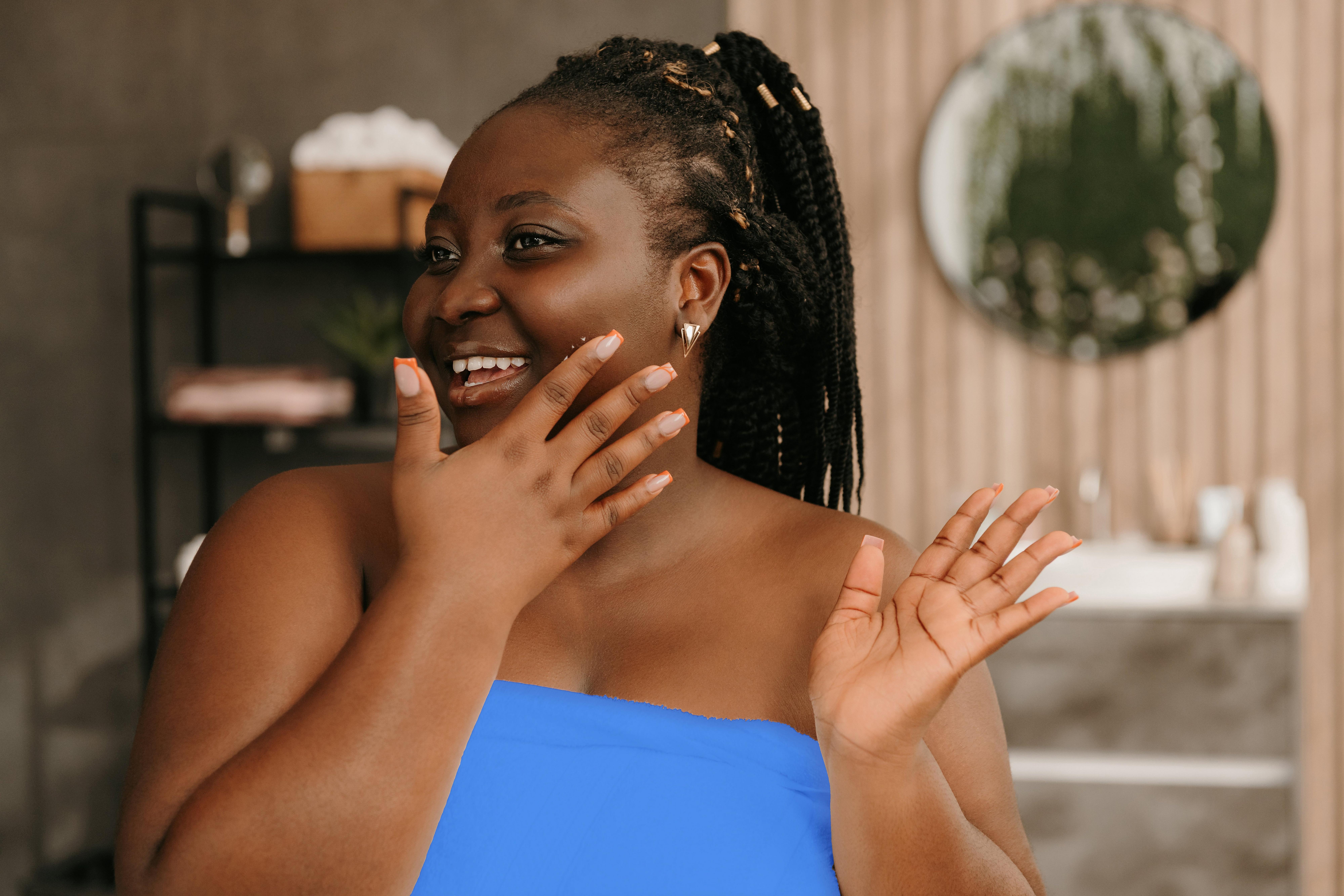 A person with a blue top and hand to their face