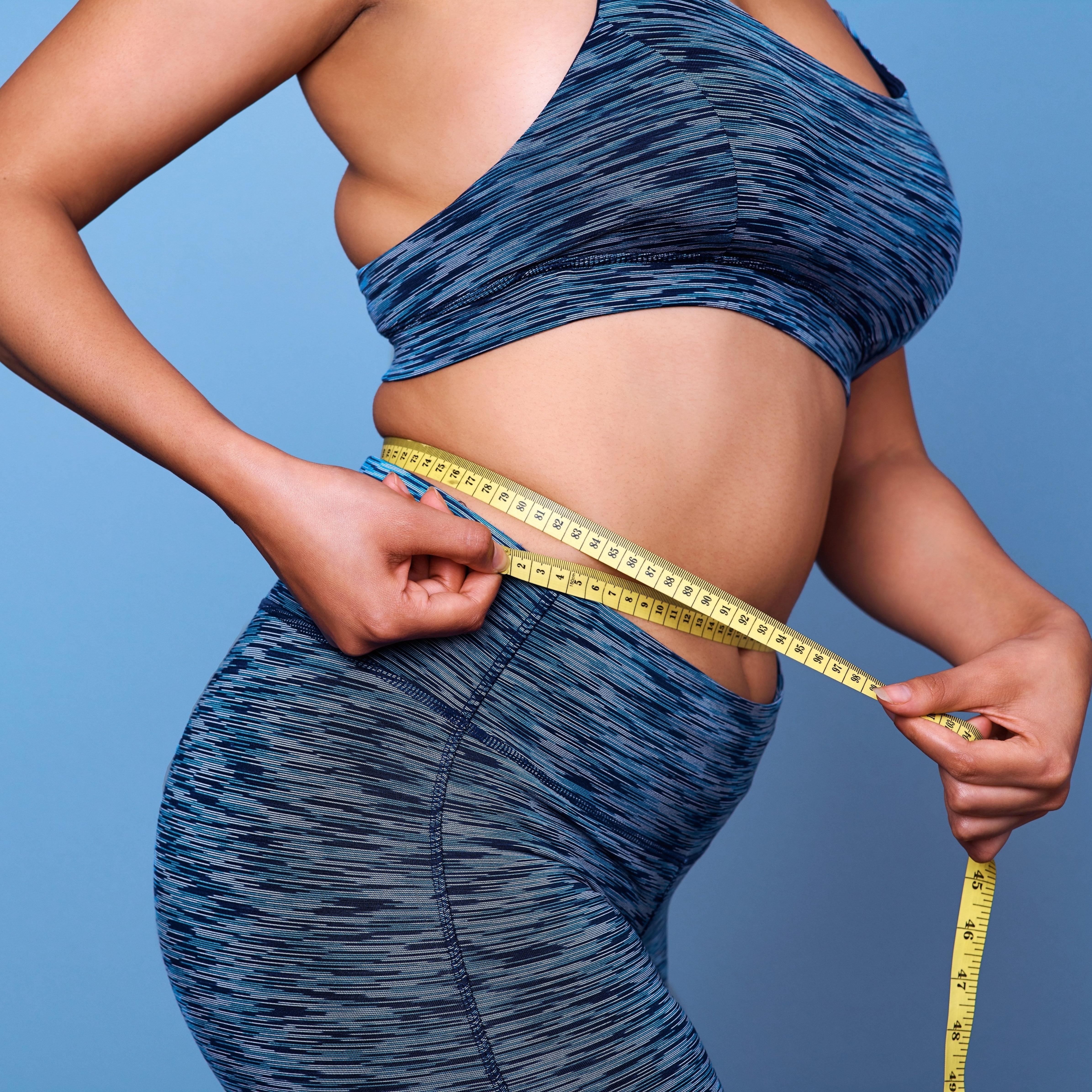 2 women wearing backpacks walking through a field