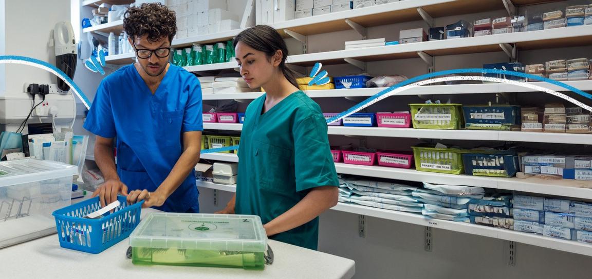 two pharmacists looking at a box of medication in a pharmacy